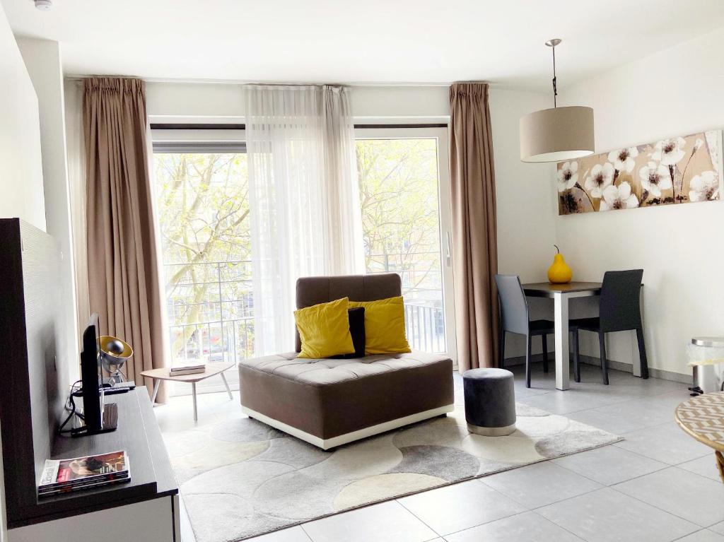 ein Wohnzimmer mit einem Stuhl und einem Tisch in der Unterkunft Quartier des Quais Dansaert in Brüssel