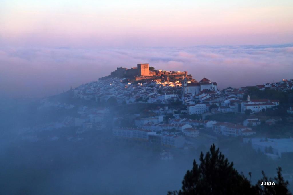 a city sitting on top of a hill in the clouds at ESPÍRITO DO LUGAR - CASTELO DE VIDE in Castelo de Vide