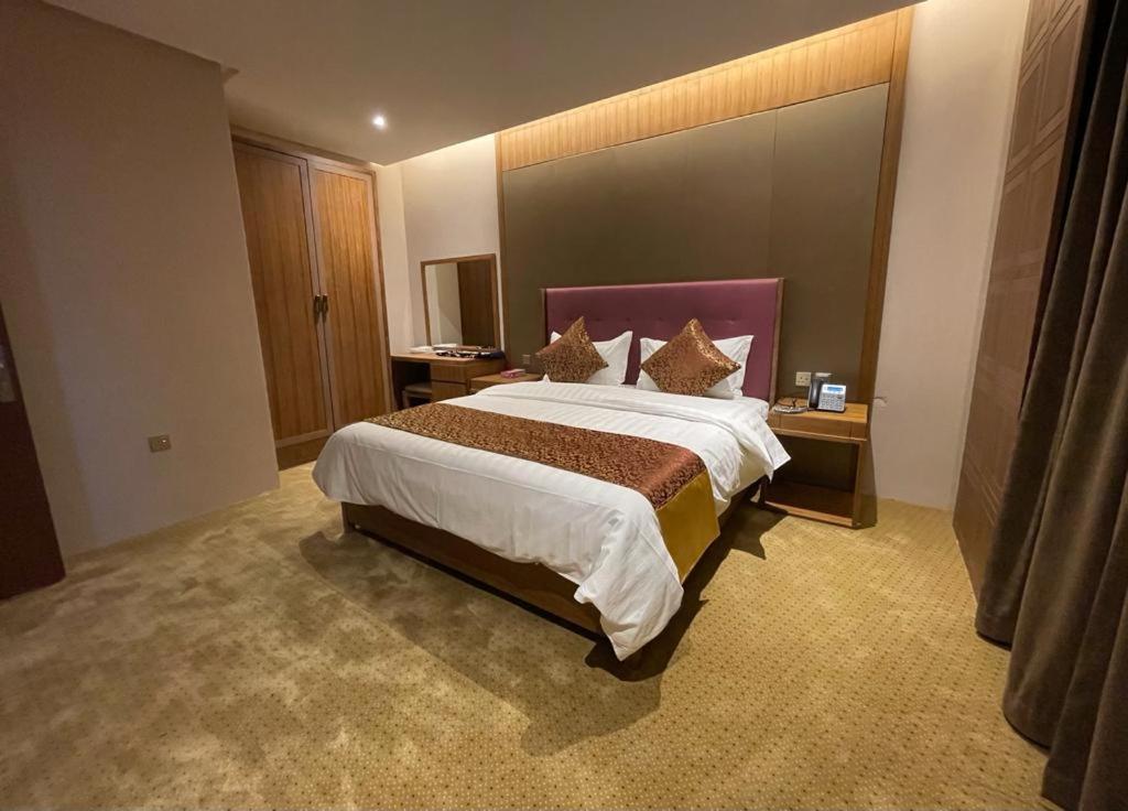 a bedroom with a large bed in a hotel room at Hosta Hotel Suites in Riyadh