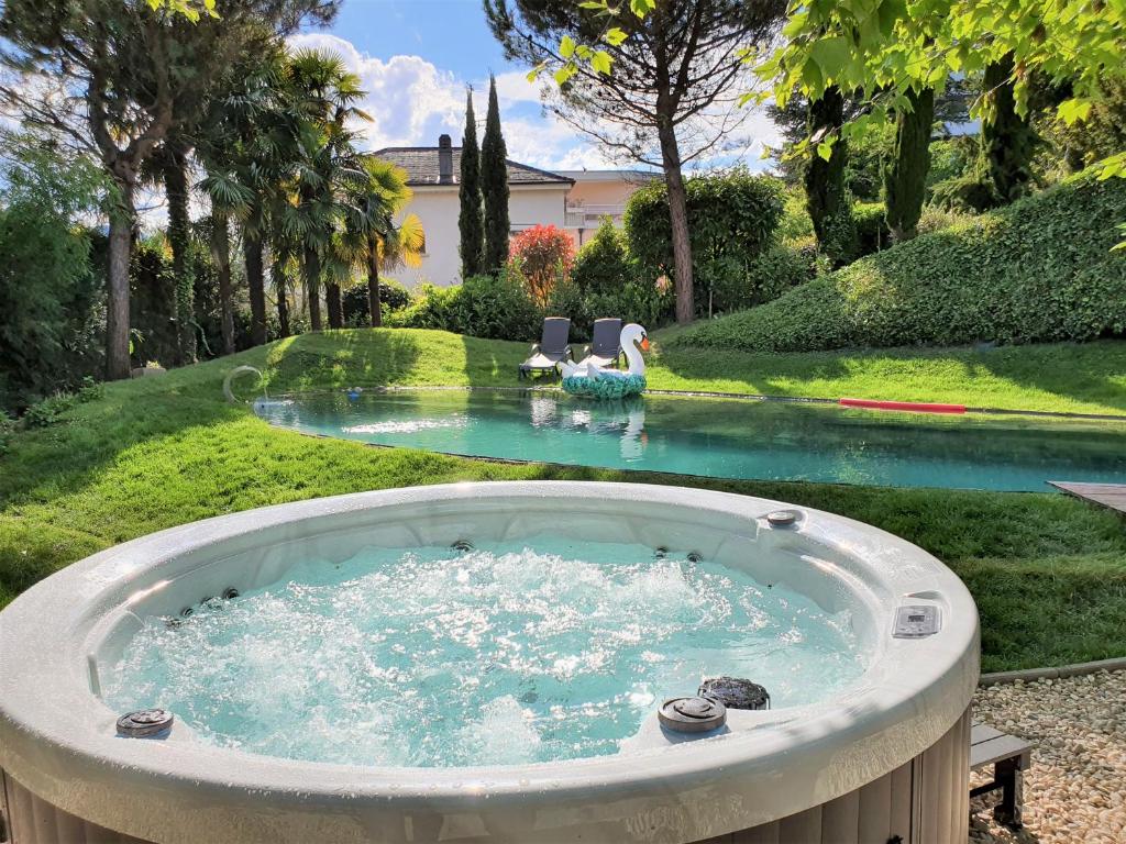 a bath tub in a yard with a pool of water at Montreux Rotana Garden House with Private Pool - Swiss Hotel Apartments in Montreux
