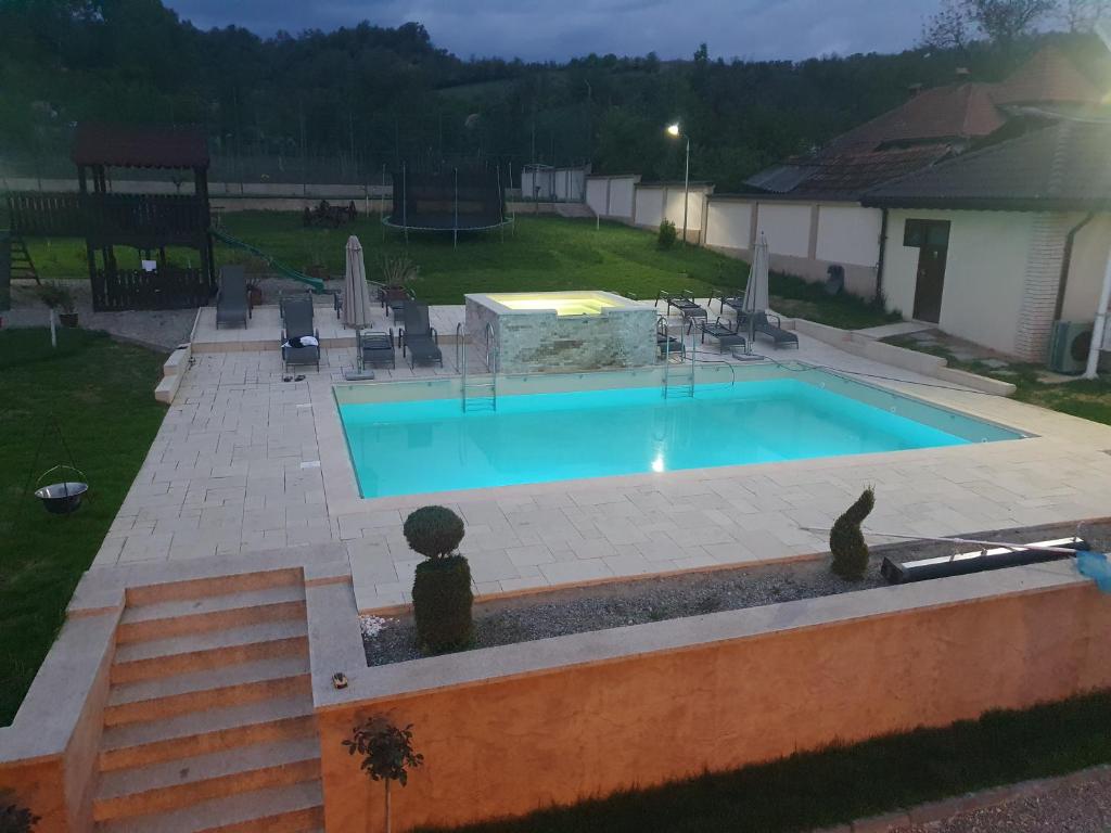a large swimming pool in a yard with a patio at Pensiunea Gabriel in Corcova