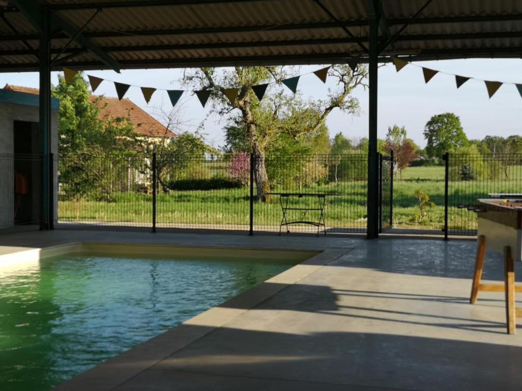 a swimming pool in a yard with a fence at La roulotte MAGIC ! des Grillots in Beaulon