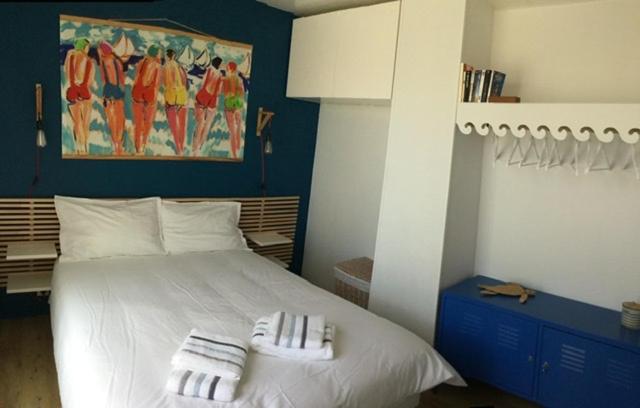 a bedroom with a white bed with two towels on it at BELLE VUE OCEAN, 2 CHAMBRES, terrasse 30m2, parking privatif et piscine en été in Lacanau-Océan