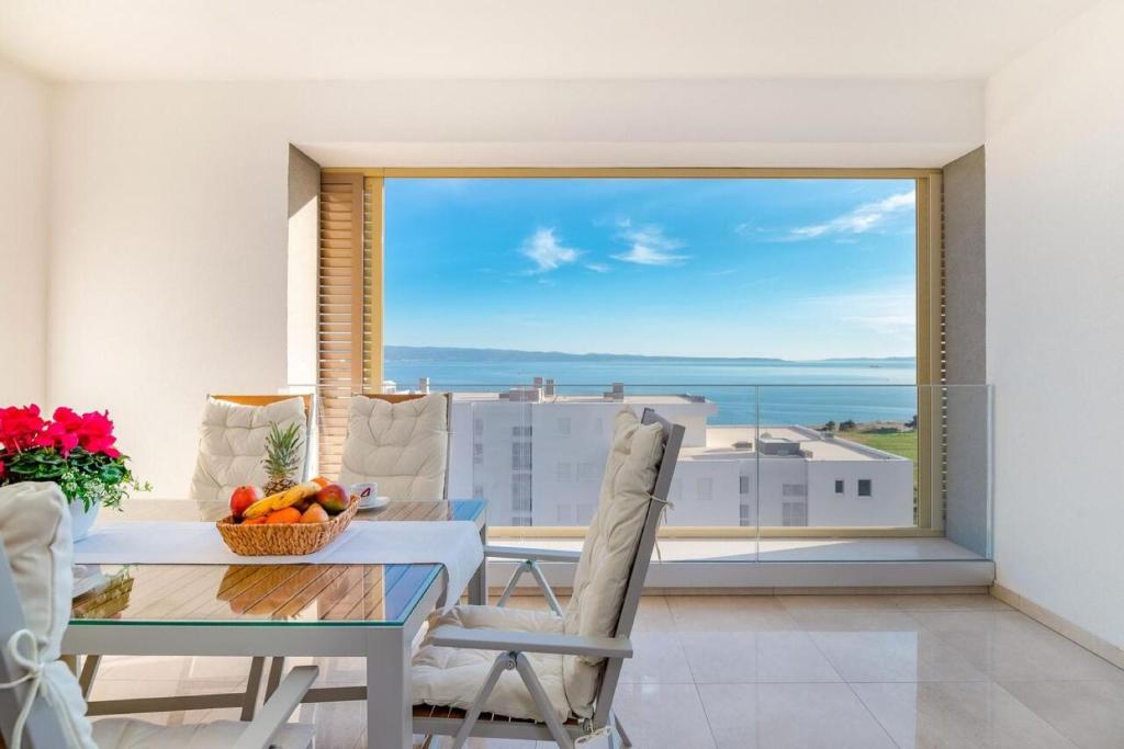 Sea view apartment Ema في سبليت: غرفة طعام مع طاولة وإطلالة على المحيط
