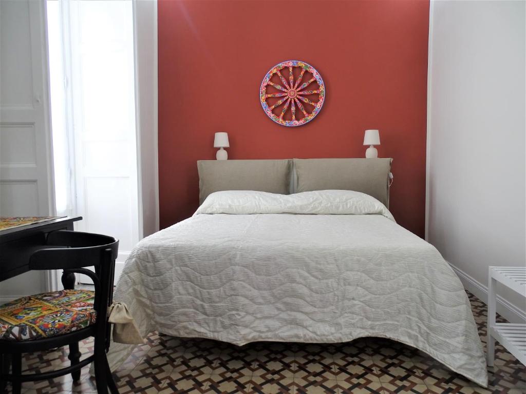 una camera da letto con un letto e una parete rossa di Sogno Etneo a Catania
