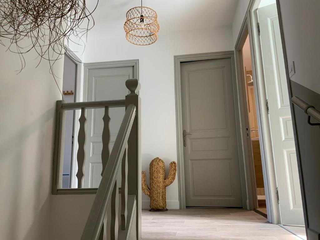 a hallway with a staircase with a mirror and a door at Appartement la corde a linge Gruissan village avec terrasses in Gruissan
