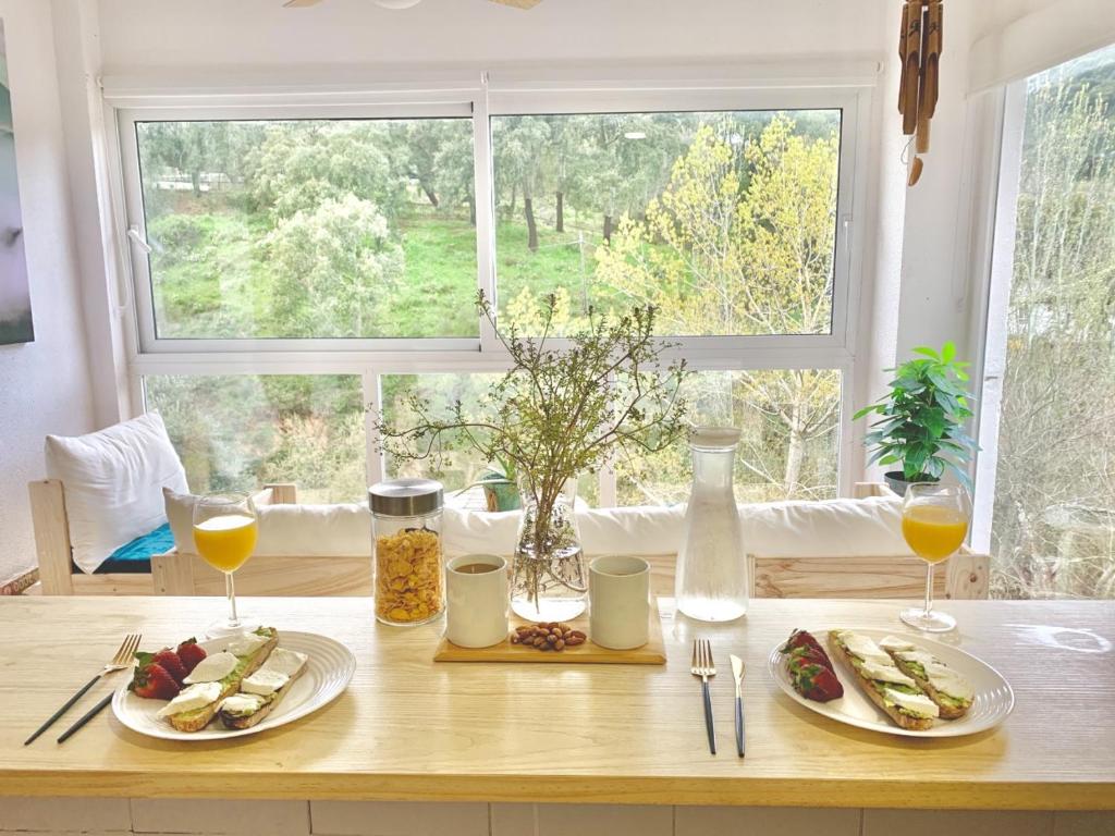 una mesa con dos platos de comida y una ventana en Casa Rural Una Ventana a la Montaña, en Aracena