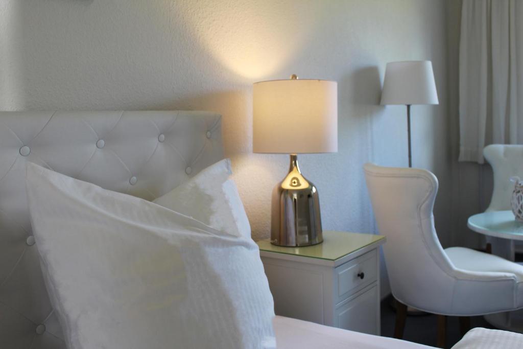 Pokój hotelowy z łóżkiem z lampką i krzesłami w obiekcie Hotel-Pension Am Fuchsberg w mieście Bad Doberan