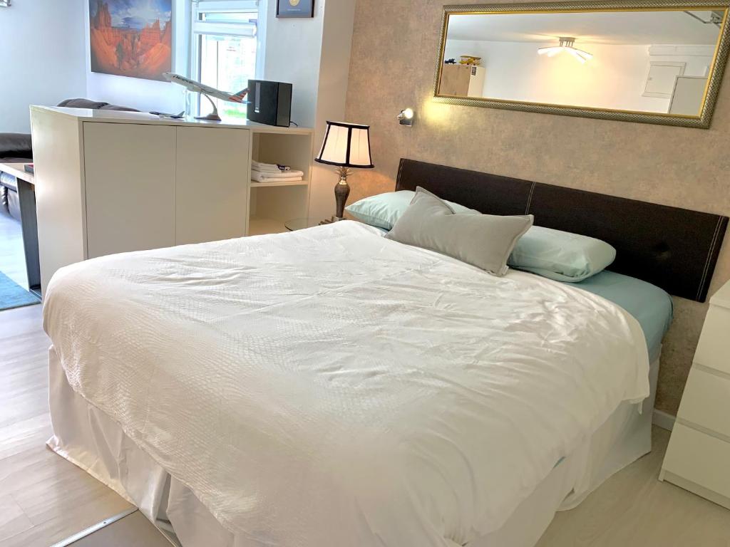 1 dormitorio con 1 cama blanca grande y espejo en The Panamericana, en Riedstadt