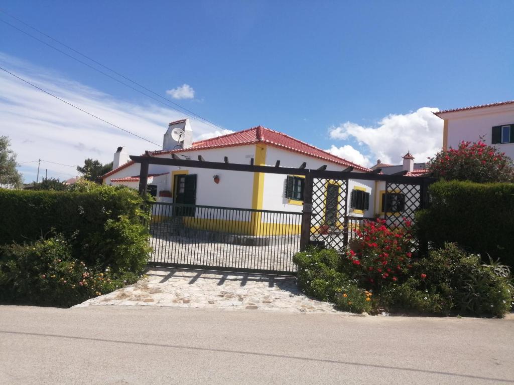 una casa amarilla y blanca con una puerta negra en Casas da Lagoa, en Santo Isidoro