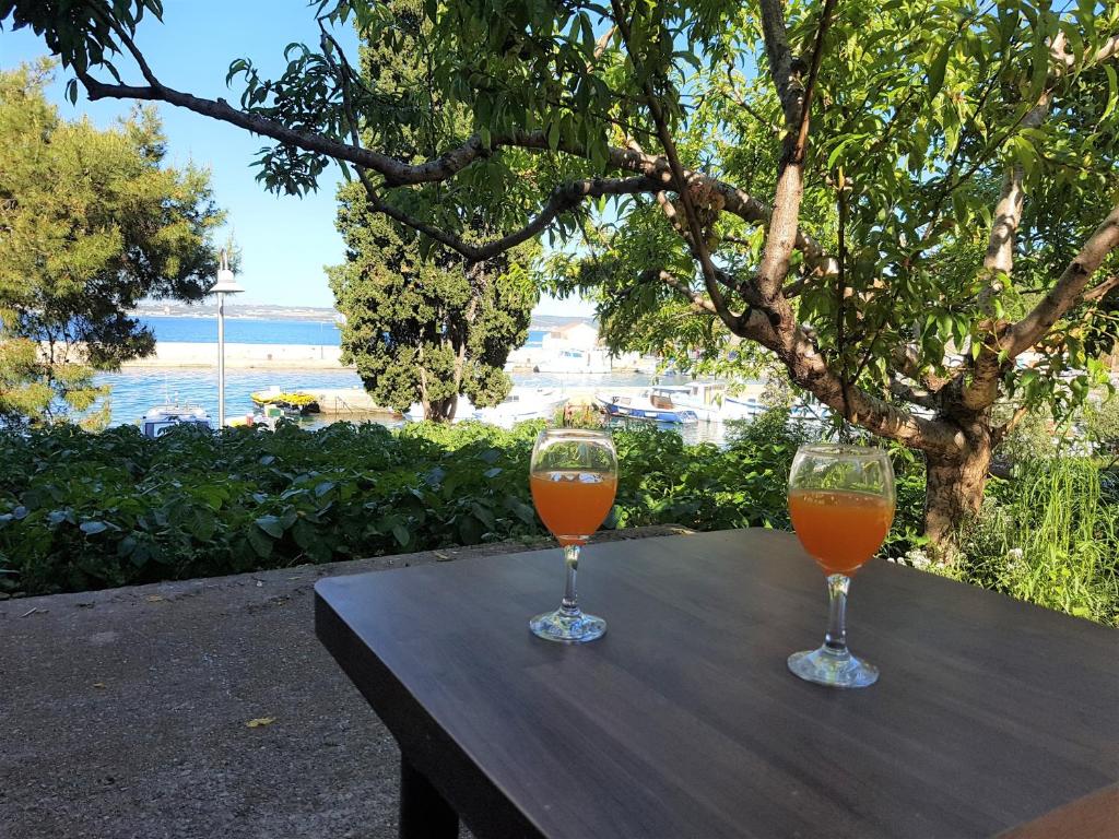 two glasses of orange juice sitting on a wooden table at Comfort apartment on the beach in Kali