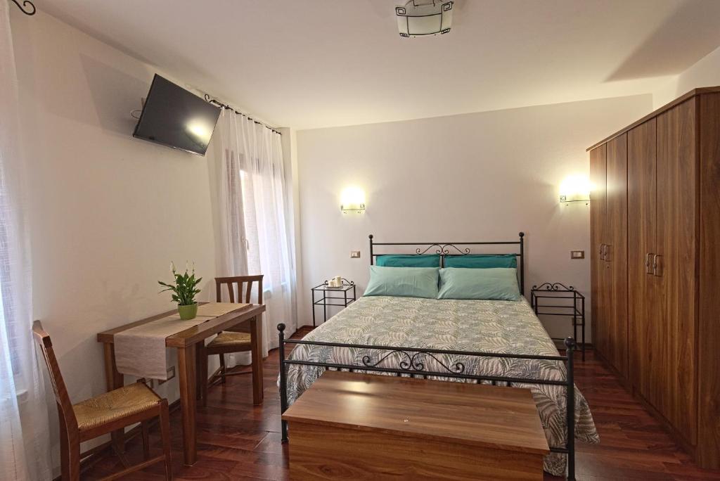a bedroom with a bed and a table and a television at B&B Sognare A Venezia in Venice