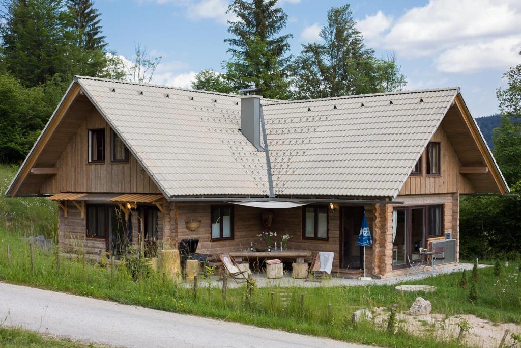 une cabane en rondins avec un toit en métal dans l'établissement Holiday Home- Mountain Lodge Gorjuše Pokljuka Bohinj, à Koprivnik v Bohinju