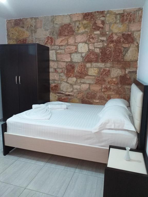 a bed in a room with a brick wall at Grand Seaview Apartments in Ksamil