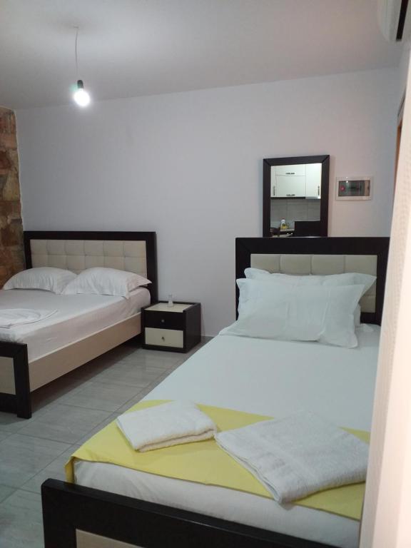 a bedroom with two beds and a mirror at Grand Seaview Apartments in Ksamil