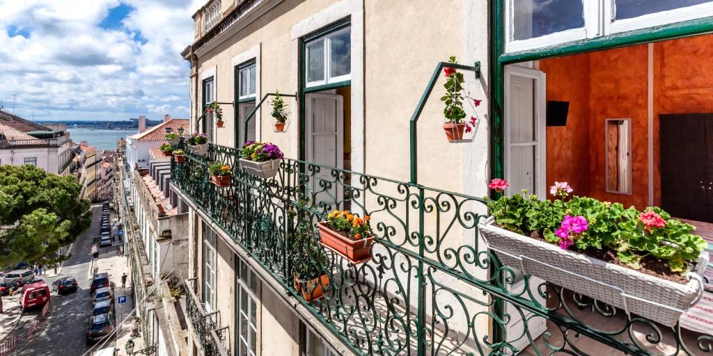 a balcony of a building with potted plants on it at Casinha das Flores in Lisbon