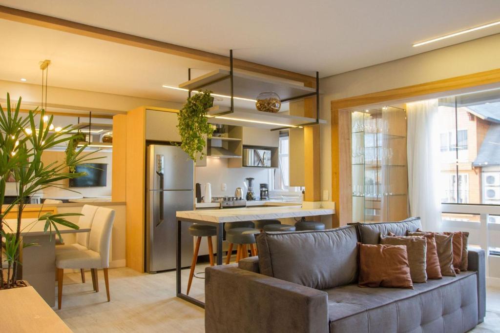 een woonkamer en een keuken met een bank en een tafel bij Incrível apartamento no Centro de Gramado in Gramado