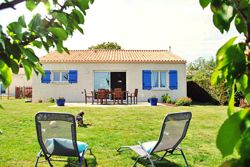 zwei Stühle im Gras vor einem Haus in der Unterkunft Maison de vacances à 10min des plages et de la Tranche sur Mer in La Jonchère