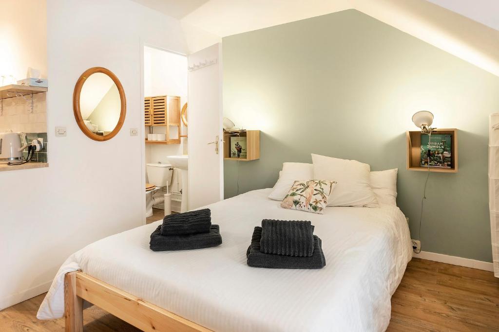 sypialnia z dużym białym łóżkiem z lustrem w obiekcie Les Logis de Marcoussis w mieście Marcoussis