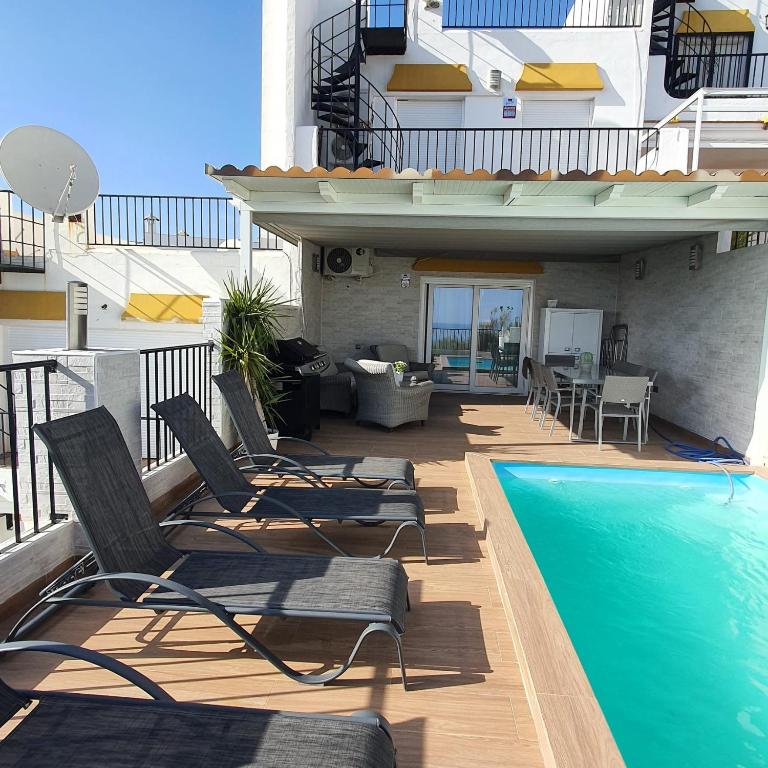 a balcony with chairs and a swimming pool at Niza Beach in Málaga