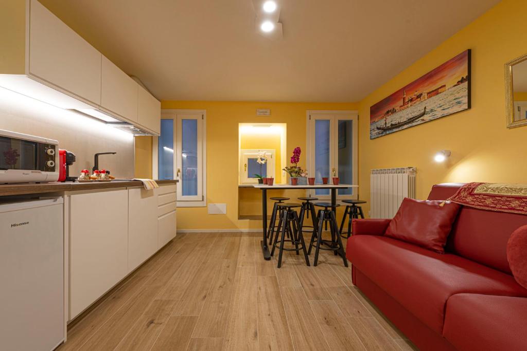 a kitchen and a living room with a red couch at NINA VENICE APARTMENT in Venice
