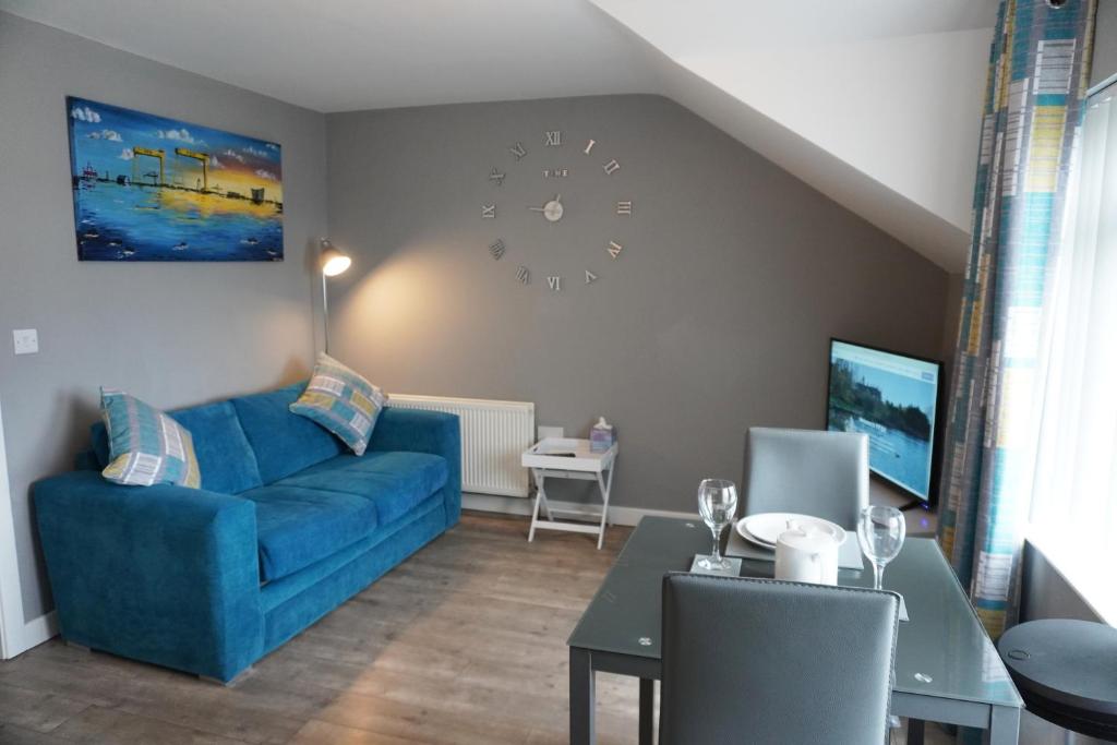 a living room with a blue couch and a table at VIP Church Loft Apartment in Portadown