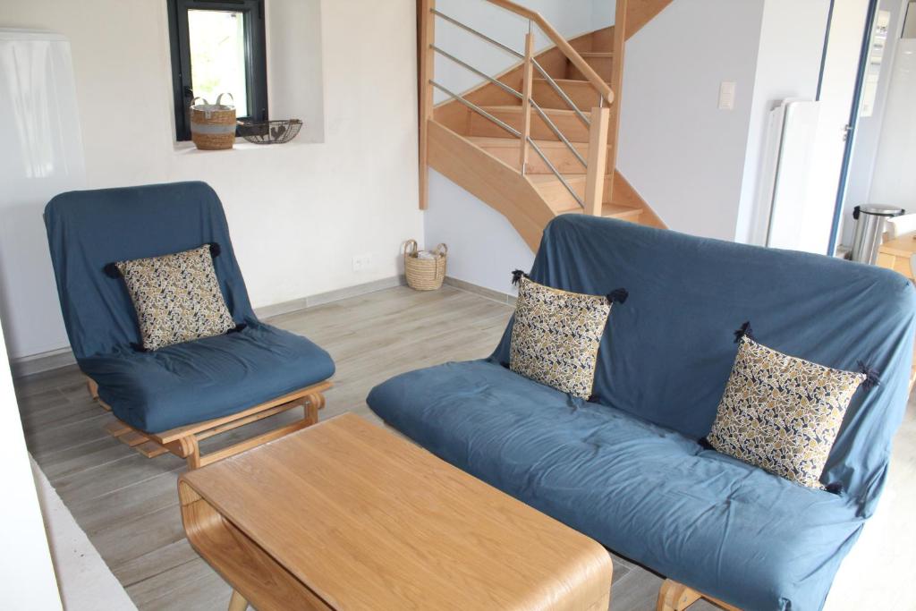 a living room with a blue couch and two chairs at Maison Belle-Ile en Mer in Bangor