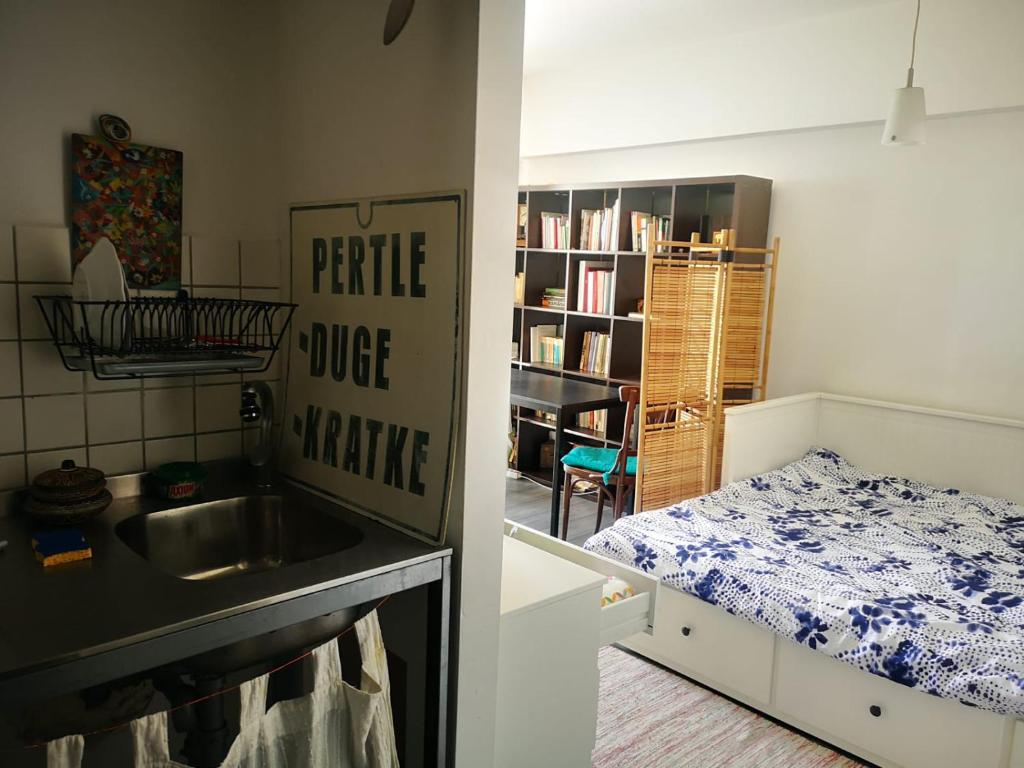 a kitchen with a sink and a bedroom with a bed at Old Town Studio in Bucharest