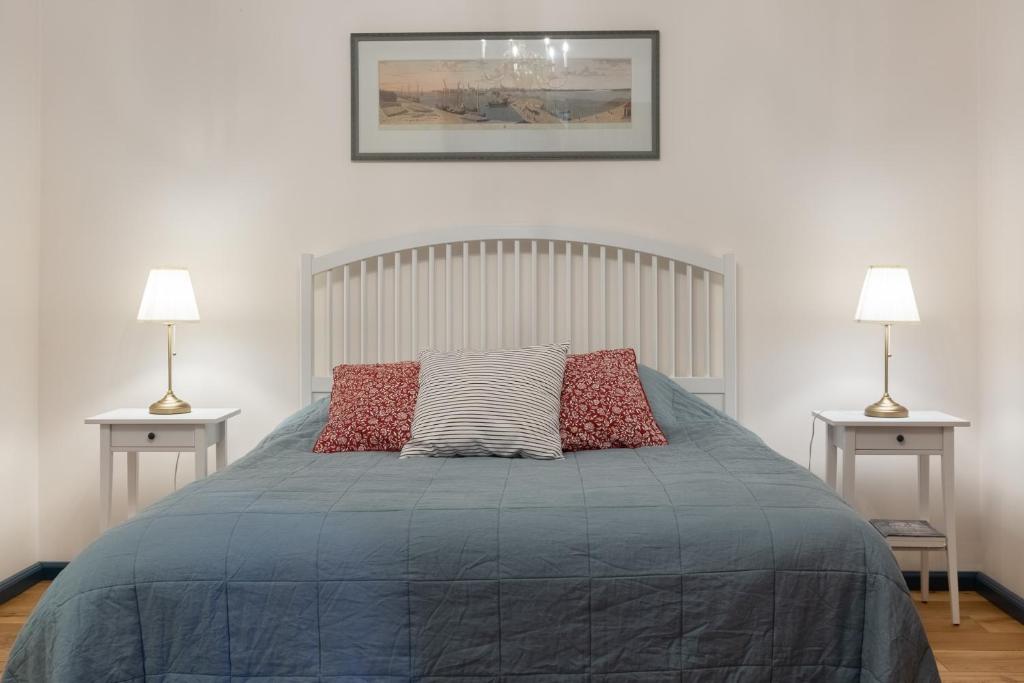 a bedroom with a large bed with two lamps at Karlamuiza Country Hotel in Kārļi