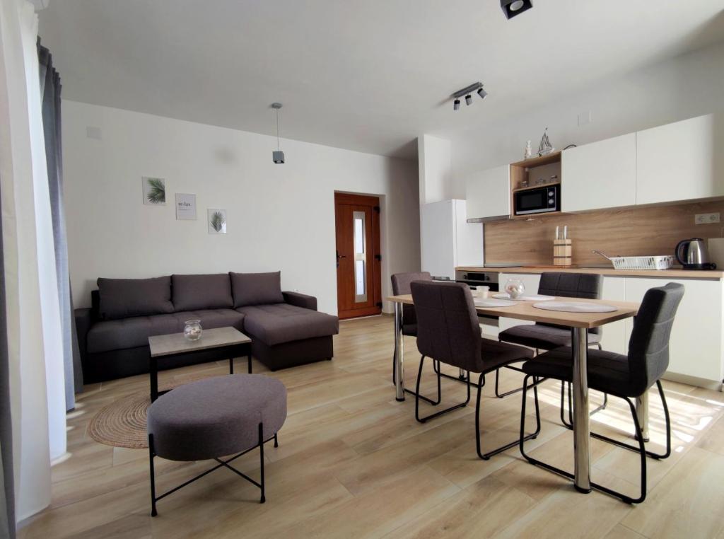 a living room with a couch and a table and chairs at Apartments Leticia in Vrsi