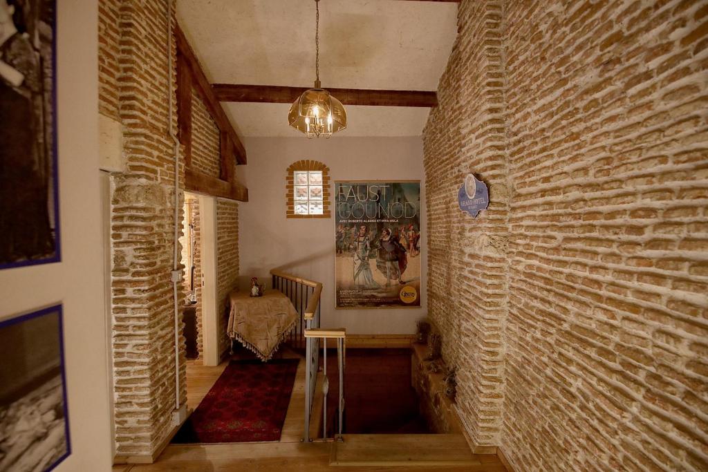 un pasillo con una pared de ladrillo y una mesa en Le Petit Secret, Korce, Albania en Korçë