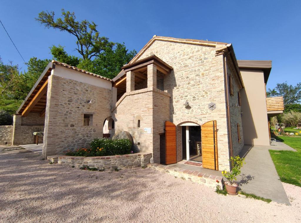 a brick building with a door in a yard at Mulino Vigoli in Morciano di Romagna