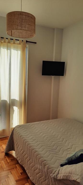 Un dormitorio con una cama y un televisor de pantalla plana. en Hermoso departamento con excelente ubicación, en Buenos Aires