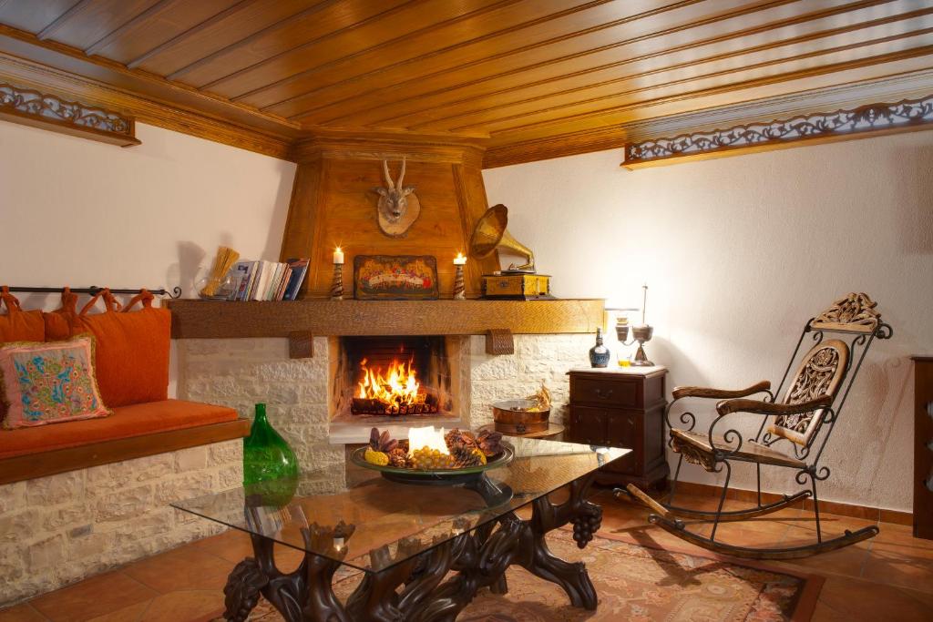 a living room with a fireplace and a table at ARCHONTARIKI Historic Boutique Hotel in Ioannina