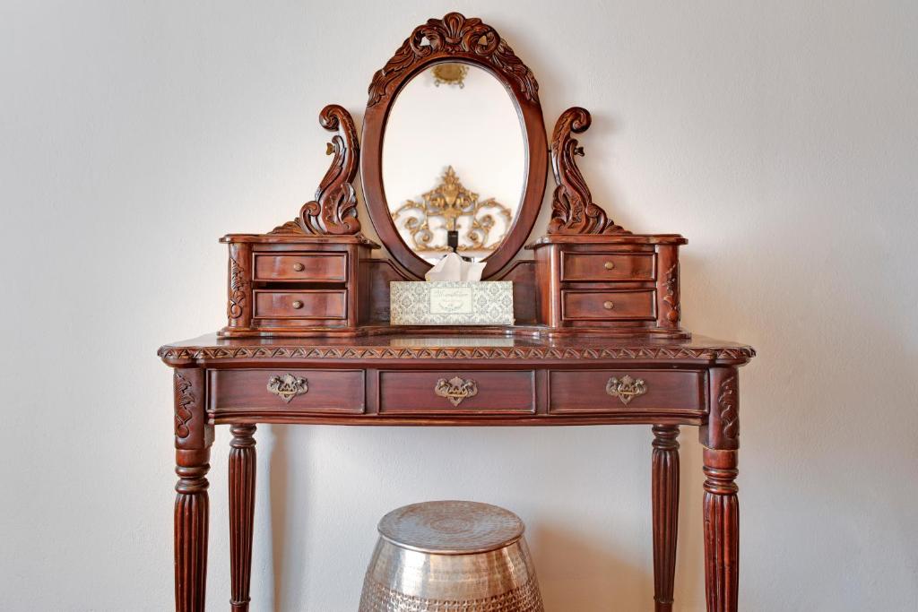a dressing table with a mirror and a stool at ARCHONTARIKI Historic Boutique Hotel in Ioannina