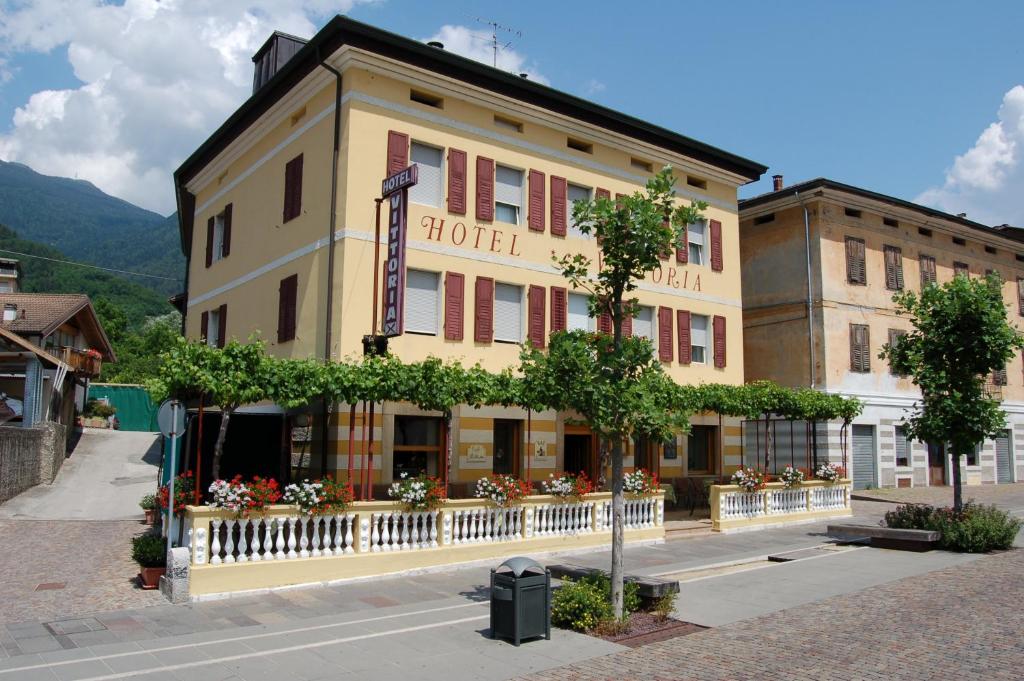 a hotel building with a fence in front of it at Hotel Vittoria in Levico Terme