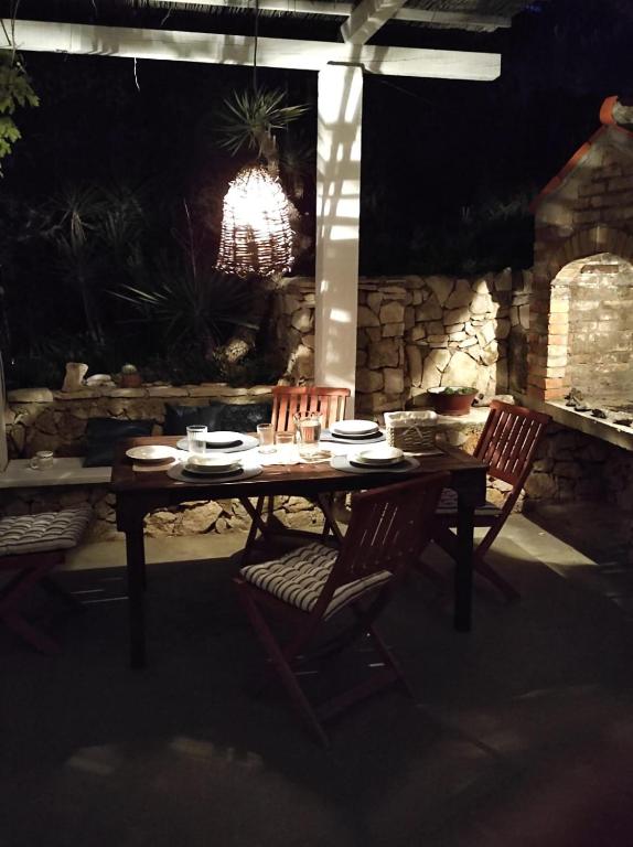 a wooden table with two chairs and a chandelier at Getaway house Gundula in Podstražje