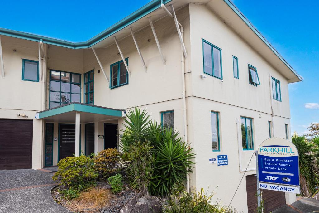 a white building with a sign in front of it at Parkhill Accommodation in Whangarei