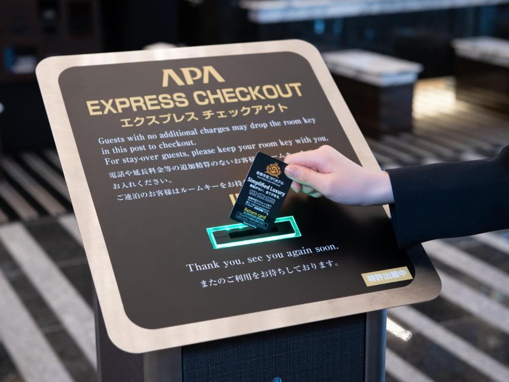 a sign for an expresscheckout with a hand on it at APA Hotel Nishifunabashi Ekimae in Funabashi