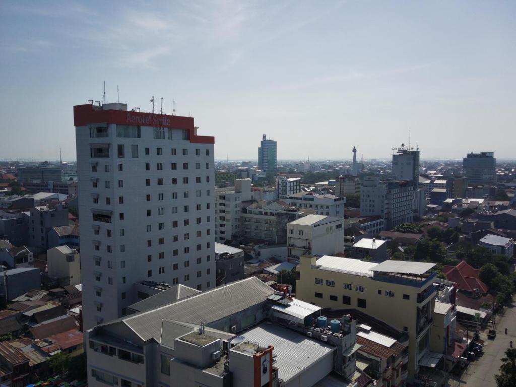 an overhead view of a city with a tall building at Aerotel Smile Losari in Makassar