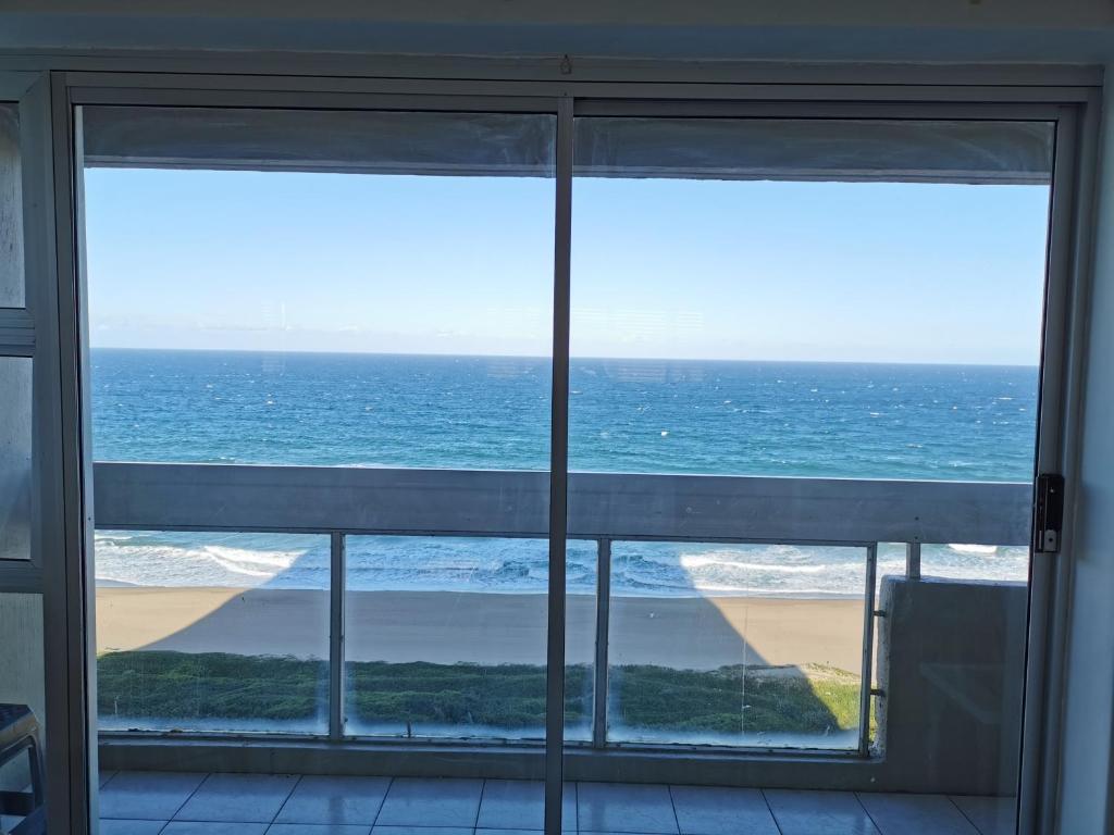 a view of the ocean from a window at Stella Maris 123 in Amanzimtoti