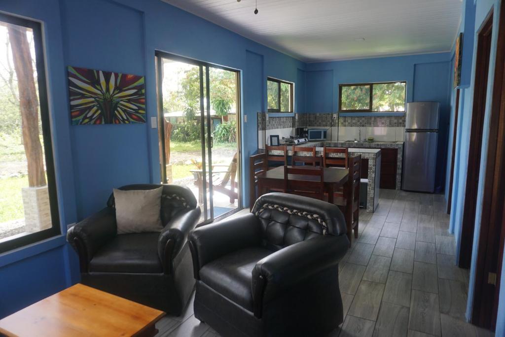 a living room with blue walls and leather chairs at Casitas Joys & Leo - Tucan in Santa Rita