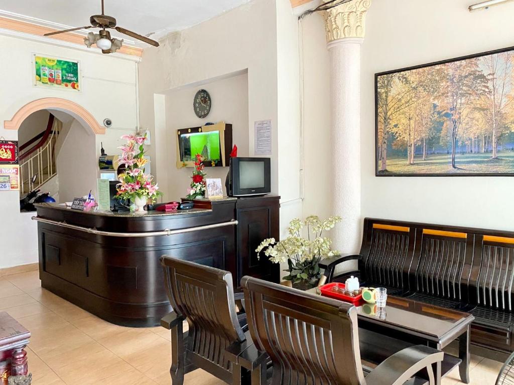 a living room with a dining table and a television at BAU CAT HOTEL in Ho Chi Minh City