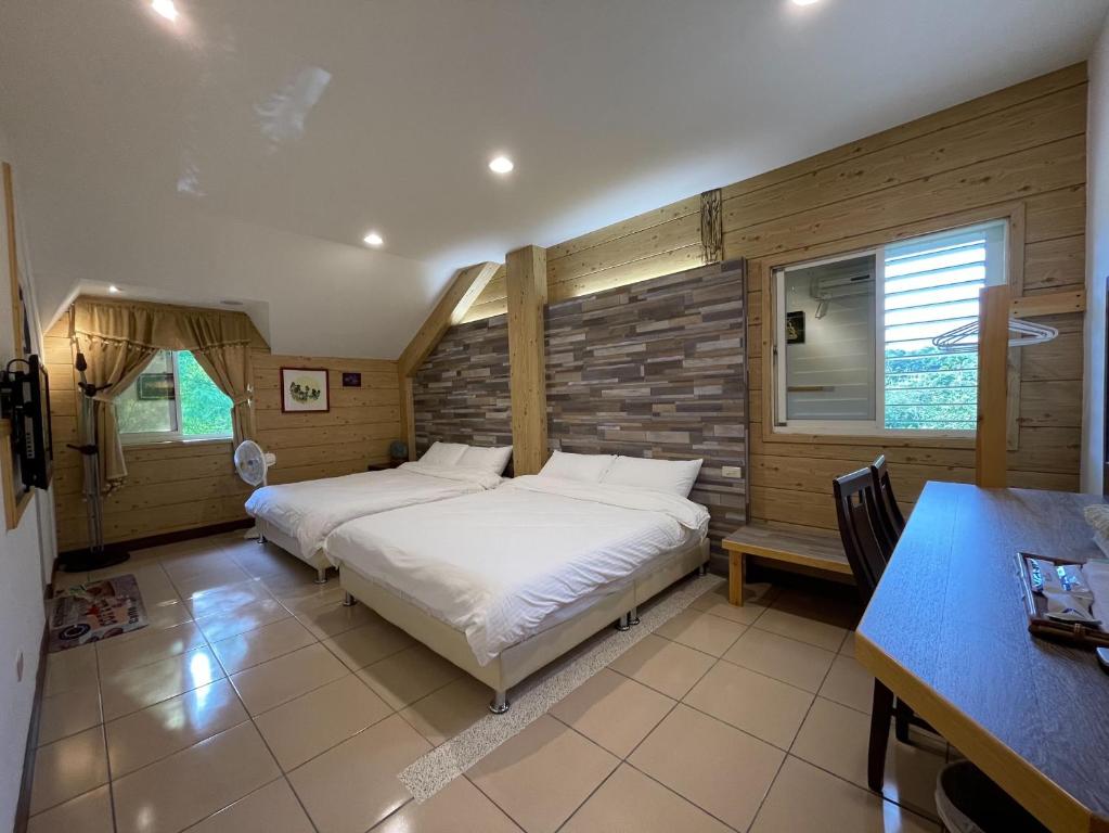 a bedroom with two beds and a table and a desk at Sao Ba Ding Homestay in Ruisui