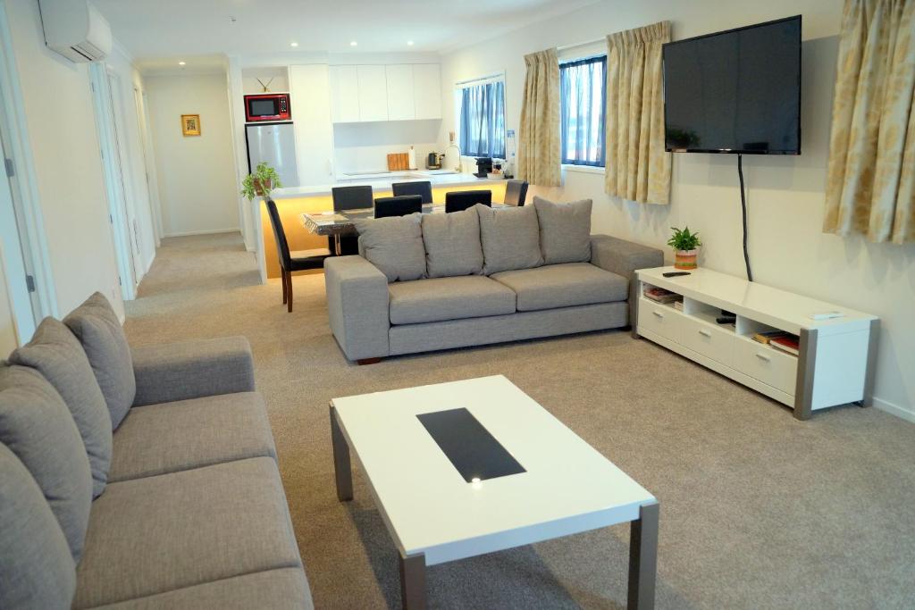 a living room with a couch and a tv at Am I in Heaven? Luxury 3 ensuite bedrooms sleeps 8 in Greymouth