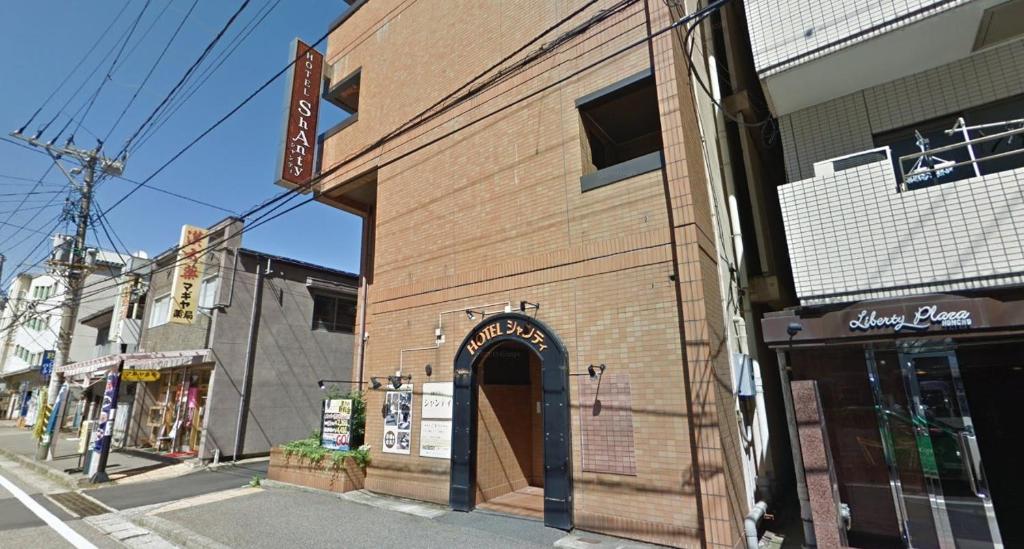um edifício de tijolos com um arco numa rua em ホテルシャンティ em Higashi-horidōri