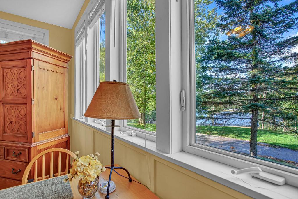 a room with two windows and a table with a lamp at White Rose Inns & Motel in Wisconsin Dells