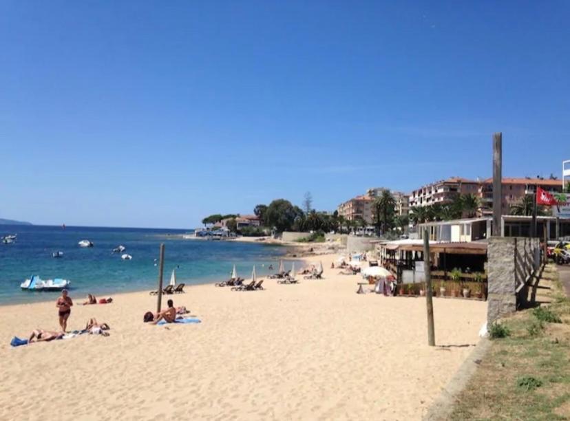 un groupe de personnes sur une plage près de l'eau dans l'établissement Ajaccio magnifique T2 neuf 40m2 avec balcon au Trottel 4 couchages wifi Clim parking plage à pieds 100m, à Ajaccio