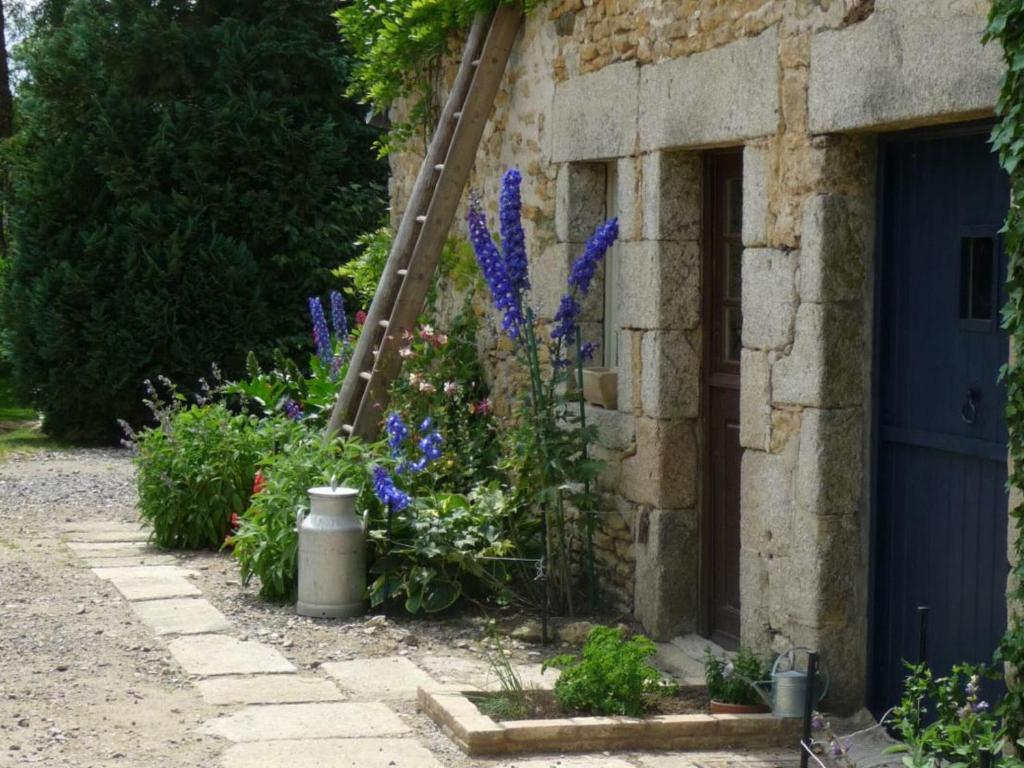 einen Garten mit lila Blumen neben einem Gebäude in der Unterkunft Gîte Écouves, 2 pièces, 5 personnes - FR-1-497-122 in Forges