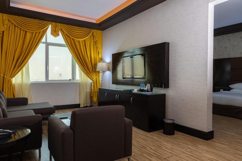 a hotel room with a bed and a living room at Mangrove Hotel in Ras al Khaimah